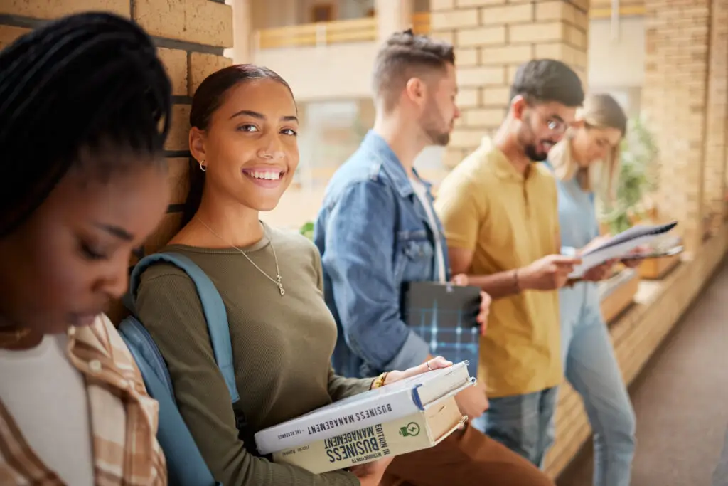 Diverse international student group standing in a hallway of a german university after coming to Germany to study with the BASTI Blocked Account package