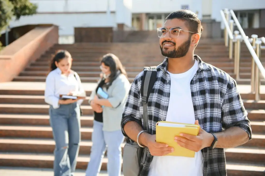 Happy international student in front of a German university after booking a Blocked Account for international students over 30